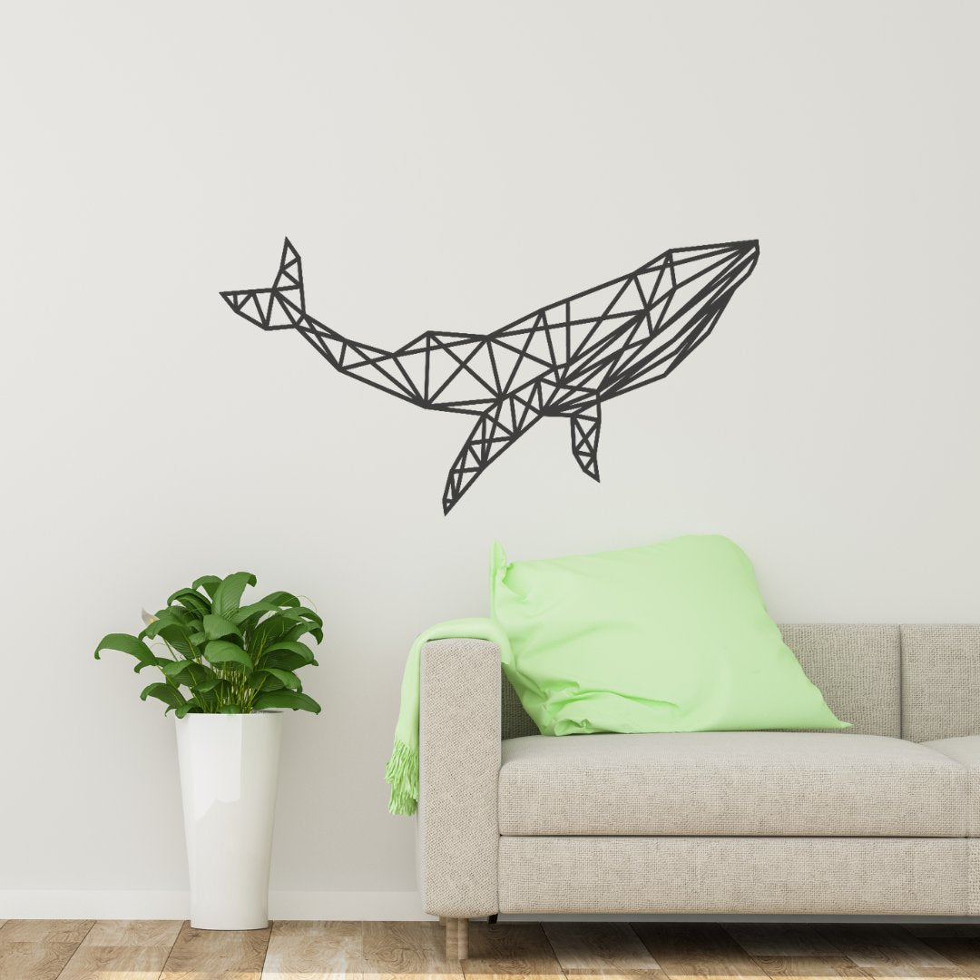 Moderne houten wanddecoratie in de vorm van een geometrische walvis, bevestigd aan een witte muur boven een stijlvolle beige bank met groene kussen en een kamerplant in een witte pot ernaast